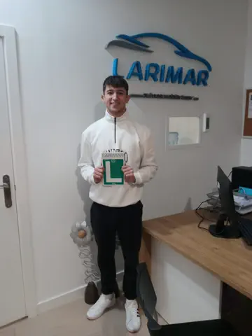 Alumno o alumna de Autoescuela Larimar con su placa L recién aprobada en la oficina (foto 24)