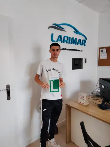Alumno o alumna de Autoescuela Larimar con su placa L recién aprobada en la oficina (foto 8)
