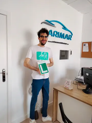 Alumno o alumna de Autoescuela Larimar con su placa L recién aprobada en la oficina (foto 5)