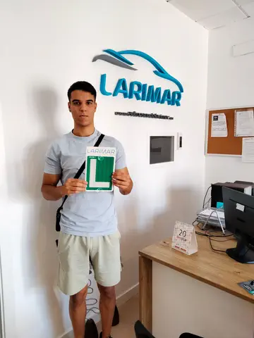 Alumno o alumna de Autoescuela Larimar con su placa L recién aprobada en la oficina (foto 4)