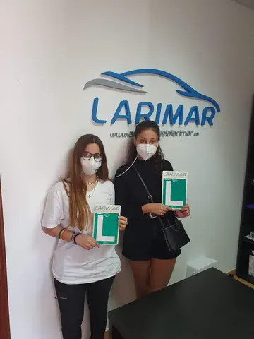Dos alumnos de Autoescuela Larimar con sus placas L en la oficina (foto 21)