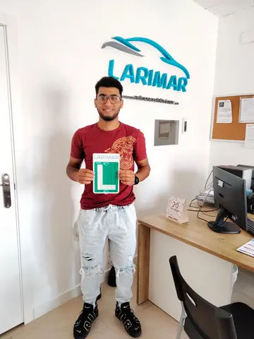 Alumno o alumna de Autoescuela Larimar con su placa L recién aprobada en la oficina (foto 10)