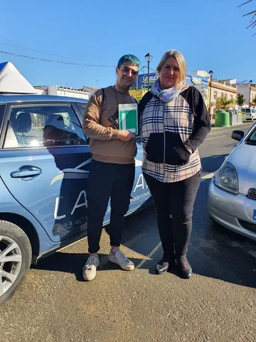Dos alumnos de Autoescuela Larimar con la placa L junto al coche de prácticas (foto 23)