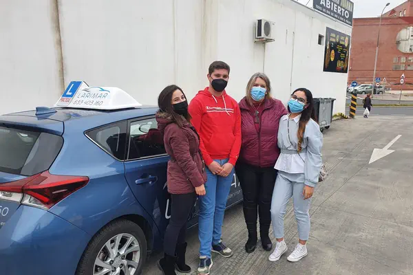 Cuatro alumnos de Autoescuela Larimar con la placa L junto al coche de prácticas (foto 17)