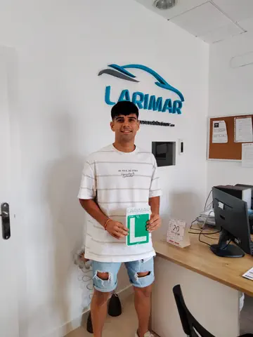 Alumno o alumna de Autoescuela Larimar con su placa L recién aprobada en la oficina (foto 9)