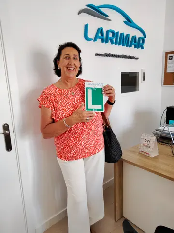 Alumno o alumna de Autoescuela Larimar con su placa L recién aprobada en la oficina (foto 3)