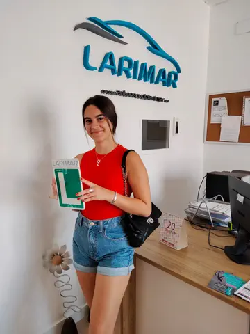 Alumno o alumna de Autoescuela Larimar con su placa L recién aprobada en la oficina (foto 1)