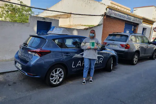 Un alumno de Autoescuela Larimar con la placa L junto al coche de prácticas (foto 13)